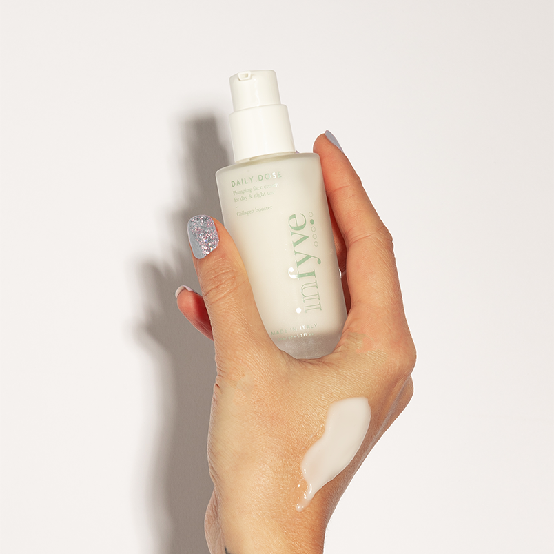 Mano che tiene il flacone DAILY.DOSE crema viso INFYVE