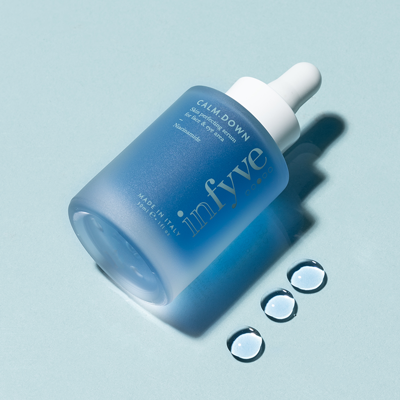 CALM.DOWN Skin Perfecting Serum INFYVE Beauty – flacone blu coricato con gocce di siero, Niacinamide Made in Italy