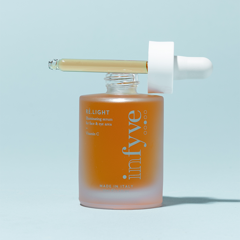RE.LIGHT Illuminating Serum INFYVE Beauty – flacone arancione aperto con contagocce, Vitamina C Made in Italy